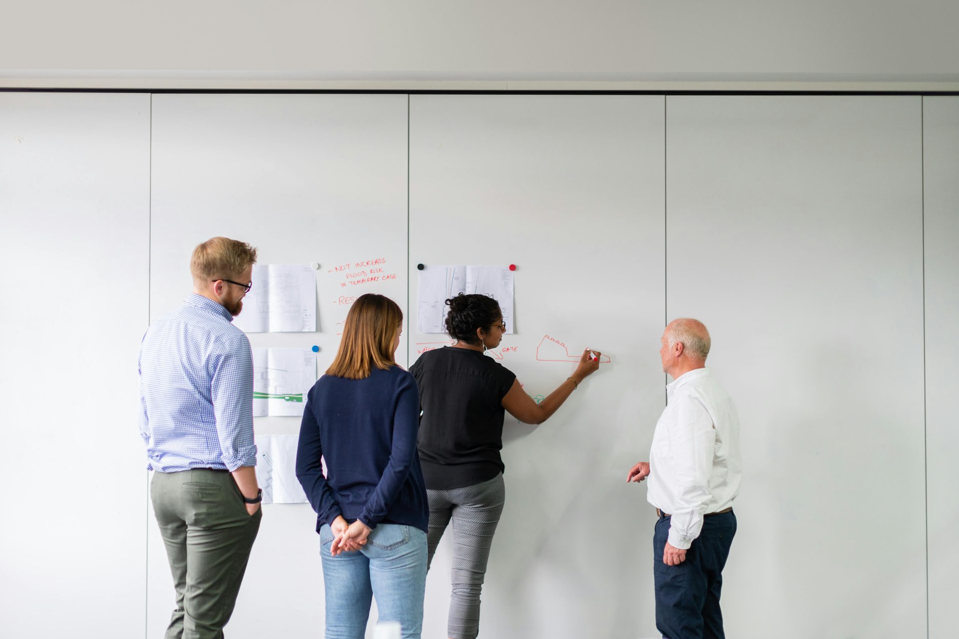 Ein Business-Team arbeitet zusammen und entwickelt Ideen in einem Besprechungsraum mit Haftnotizen.