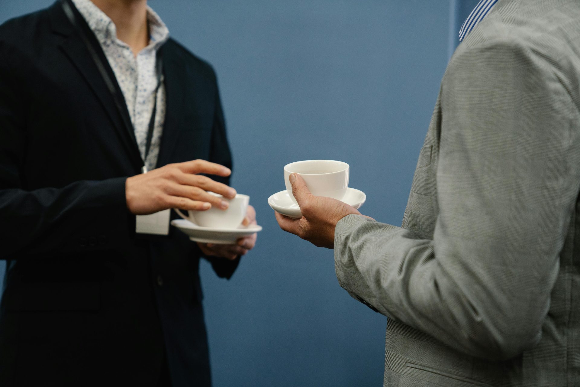 Zwei Geschäftsleute halten Kaffeetassen während eines lockeren Treffens oder einer Veranstaltung.