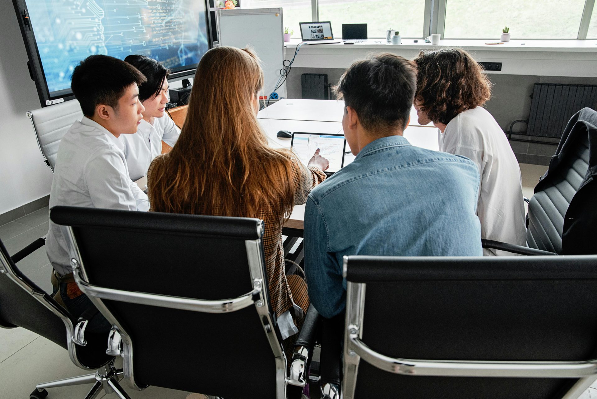 Ein Team führte in einem modernen Büroumfeld ein gemeinsames Meeting an einem Tisch.
