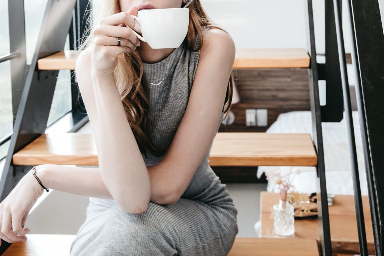 Frau mit Kaffeetasse auf Treppe