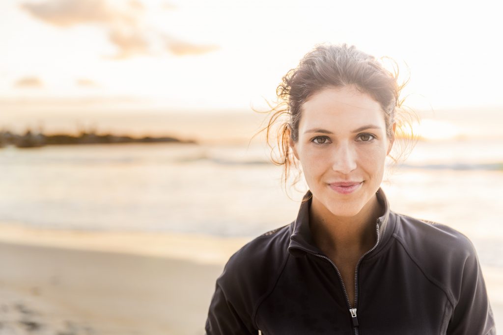 Frau am Strand bei Sonnenuntergang