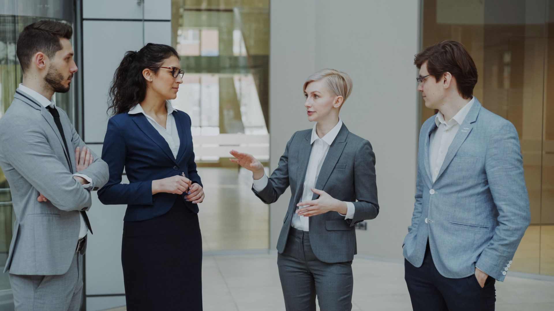 Geschäftsleute in Anzügen besprechen in einem modernen Büro eine Strategie.
